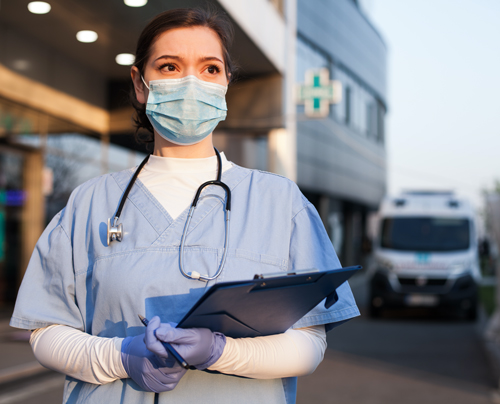 nurse standing in front of hospital